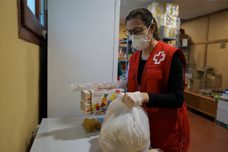 Imatge persona de Creu Roja preparant un paquet de menjar